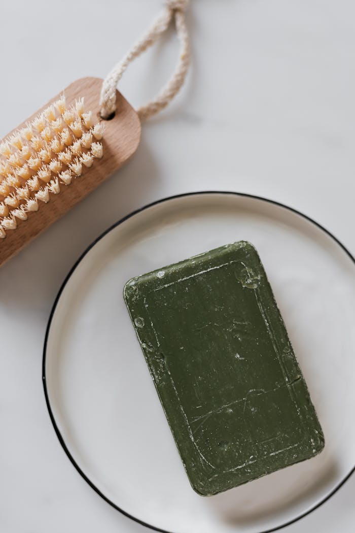 Crafting Captivating Headlines: Your awesome post title goes here Top view of natural green soap on plate beside wooden body brush.